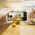 スマートフォンで建築中の写真を確認する施主